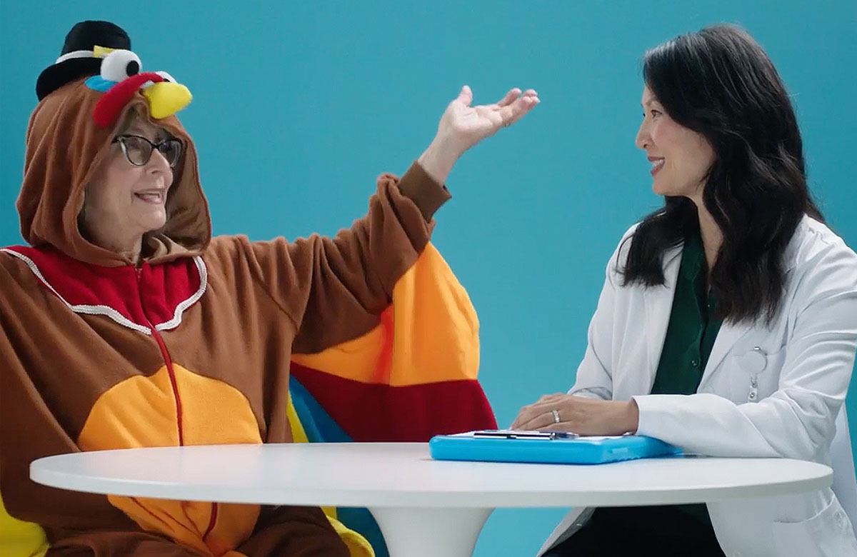 Hill Physicians - Woman dressed as a turkey and a female physician sitting at a table